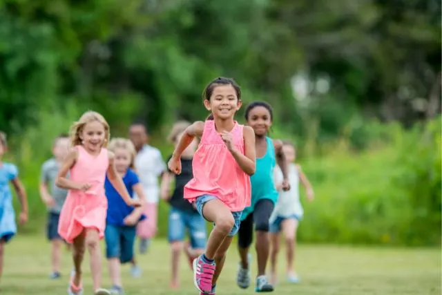 a group of children run across a field