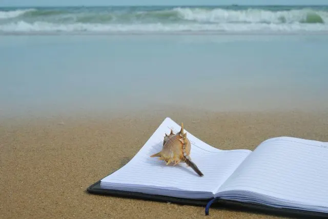 a notebook lying on a beach