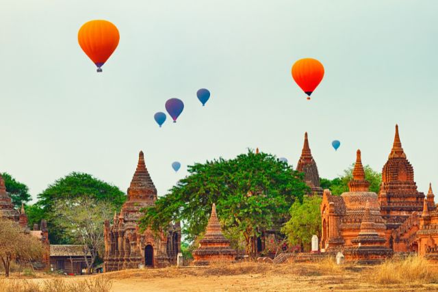 hot air balloons fly over a town