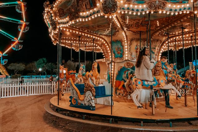 a woman rides a carousel