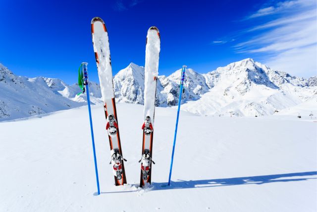 two skis and two poles stick out of a snowbank